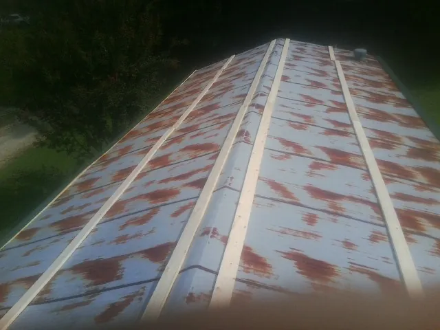 Rusted metal roof panels with new wood purlins before replacement — Storm Damage Roof Repair in Alvada by Roofing Brothers