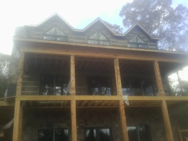 Dormers and porch framing on a large log home under construction — Roof Coating work by our crew in Alvada